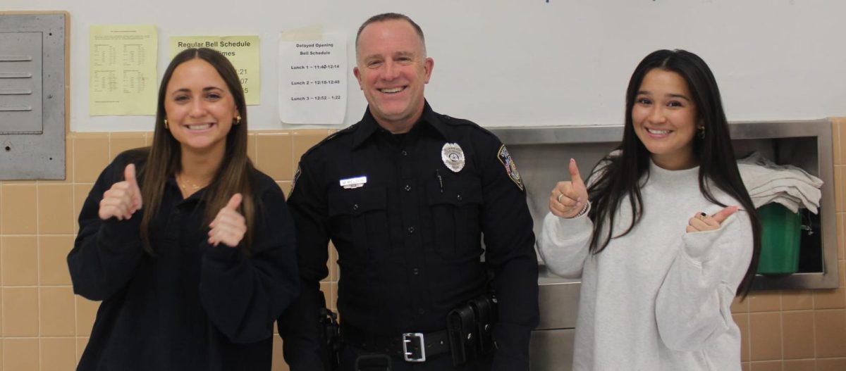 Students Eva Critchley (left) and Joelle RIcafort (right) posing with their SRO officer, Officer Weldon (middle). 